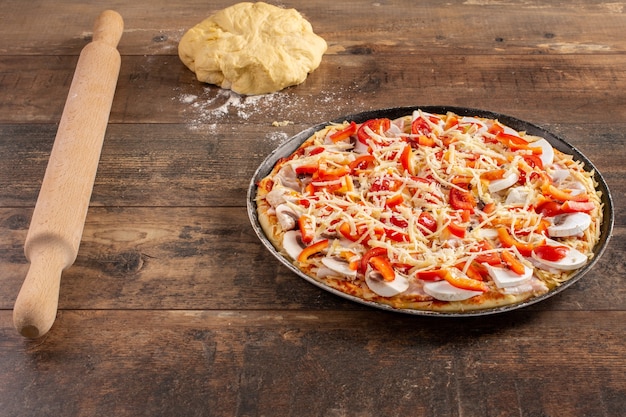 Pizza crua caseira com tomate, cogumelos, presunto e queijo