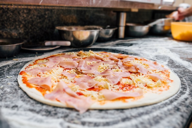 Pizza cruda en el mostrador de la cocina.