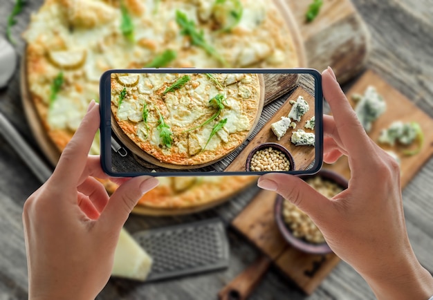 Pizza cuatro quesos en la mesa de madera