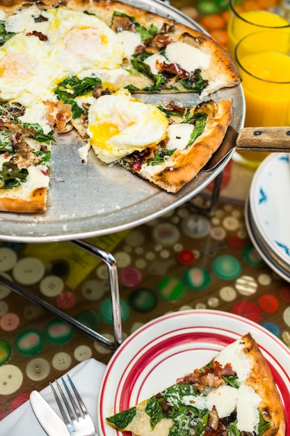 Pizza de café da manhã fresca com três ovos frescos de fazenda no restaurante italiano.