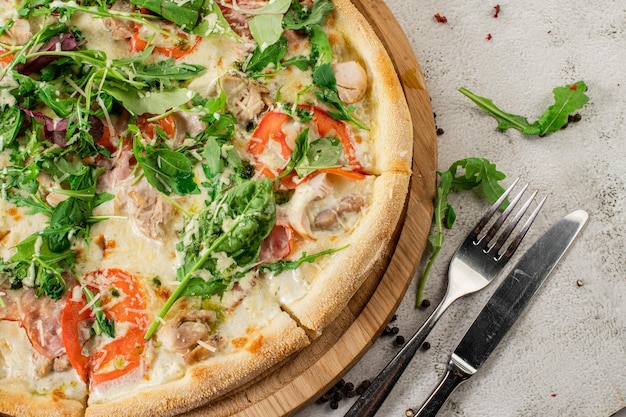 Pizza de carne com presunto e queijo no fundo branco de concreto