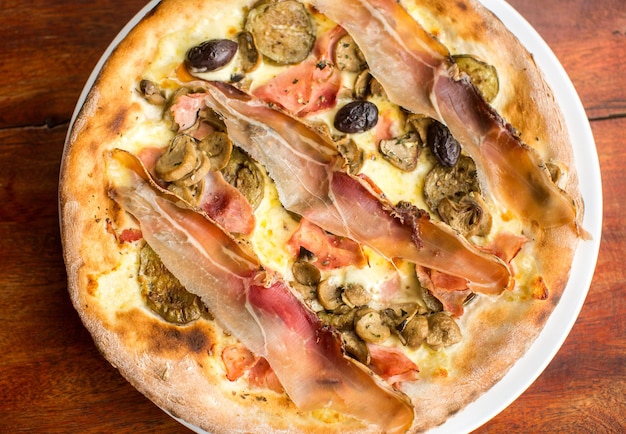 Pizza de carne variada com jamon e azeitonas