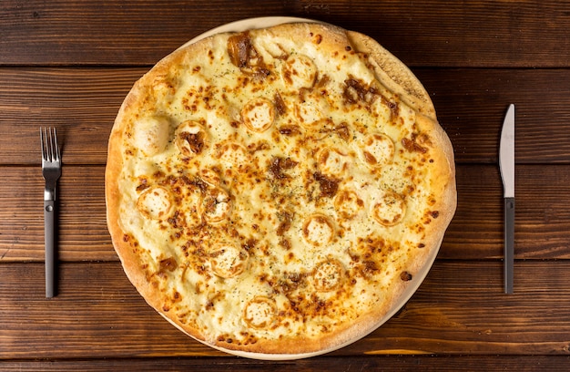 Pizza de cima com queijo e talheres