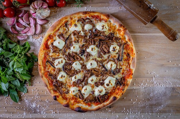 Pizza de cogumelos e creme de queijo shimeji em cima da mesa