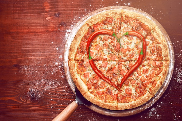 Pizza de dia dos namorados com pimentos em cima de uma pizza