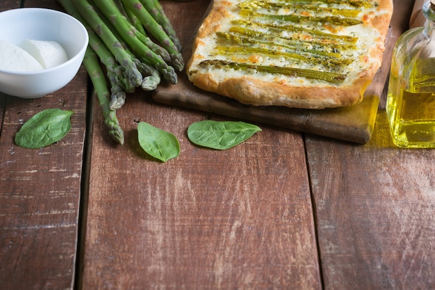 Pizza de espargos verdes com ervas e fundo de mussarela