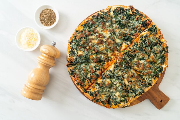 Pizza de espinafre e queijo em bandeja de madeira - estilo de comida vegana e vegetariana