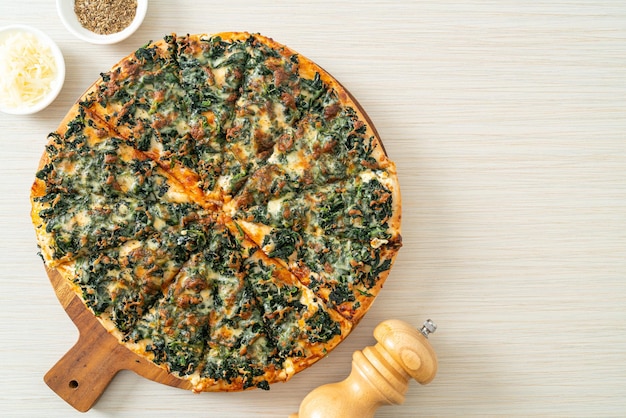 Pizza de espinafre e queijo em bandeja de madeira - estilo de comida vegana e vegetariana