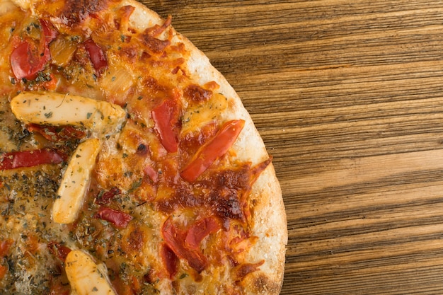 Pizza de frango redonda em uma mesa de madeira