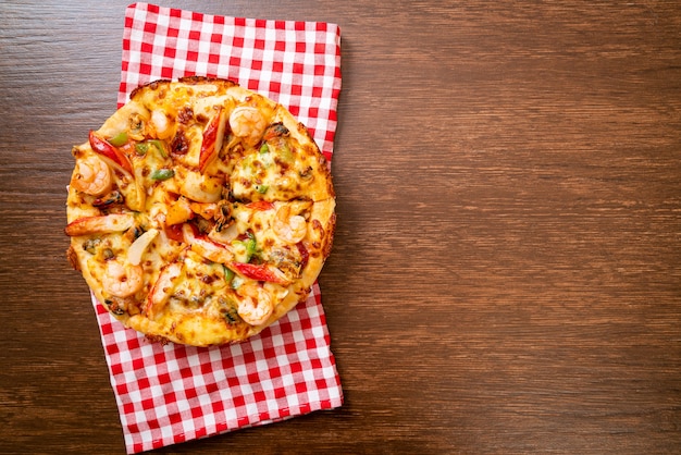 Pizza de frutos do mar (camarão, polvo, mexilhão e caranguejo) em bandeja de madeira