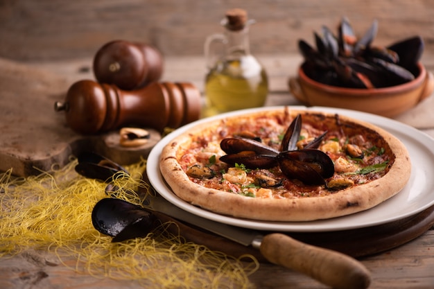 Pizza de frutos do mar em uma mesa de madeira rústica de perto