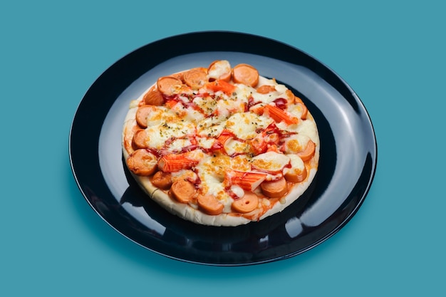Pizza de linguiça e caranguejo em uma placa de cerâmica isolada em fundo de cores pastel.