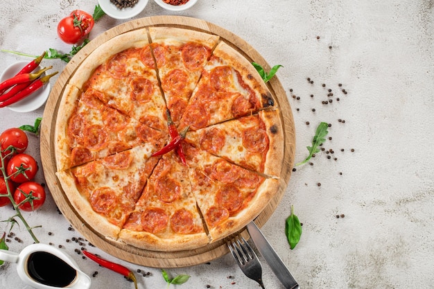 Pizza de pepperoni com carne e pimenta no fundo de concreto