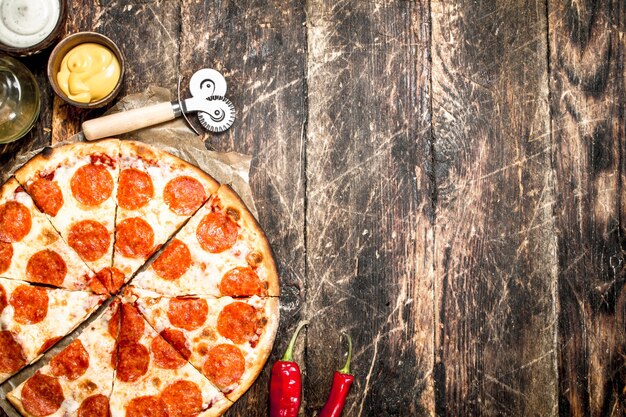 Foto pizza de pepperoni com molhos
