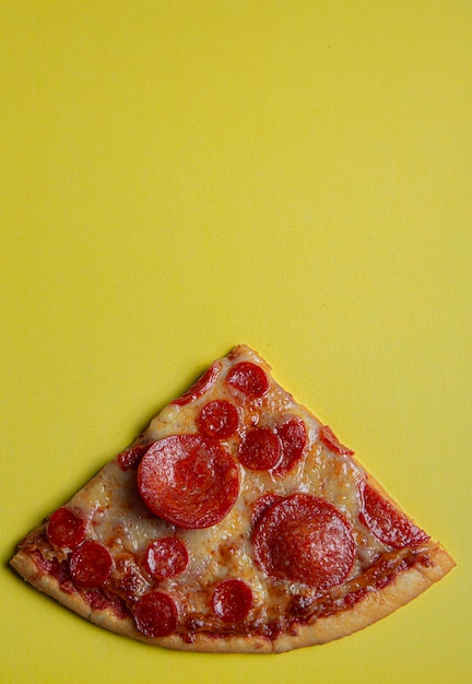 Pizza de pepperoni em fundo de cor amarela