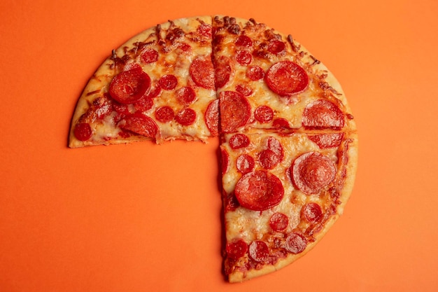 Pizza de pepperoni em fundo de cor laranja