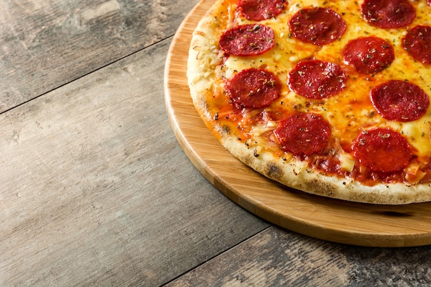 Pizza de pepperoni italiana quente na mesa de madeira