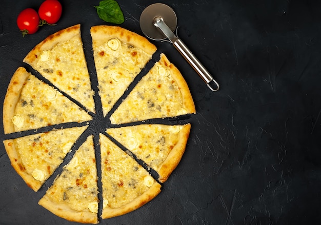 Pizza de quatro queijos com diferentes tipos de queijo em um fundo de pedra