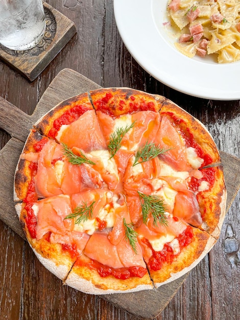 Pizza de salmão defumado na bandeja de madeira