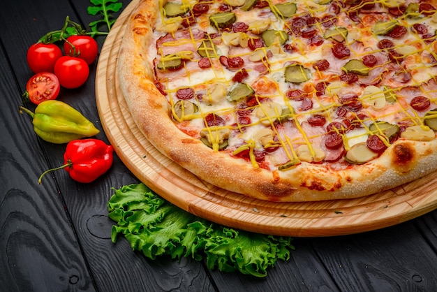 Pizza deliciosa e fresca com salsicha de presunto e pepinos em conserva