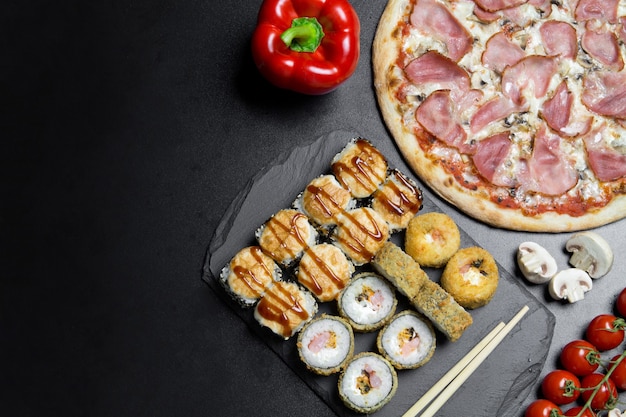 Pizza e rolinhos de sushi em um tabuleiro