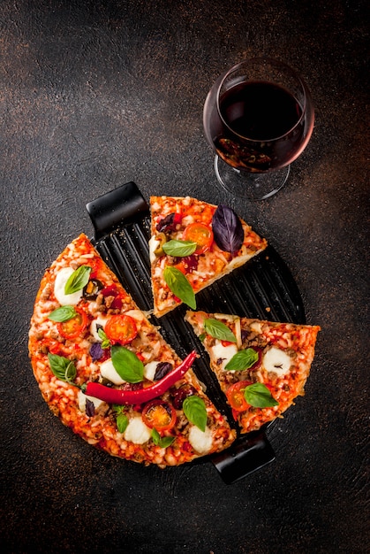 Pizza e vinho tinto em fundo escuro