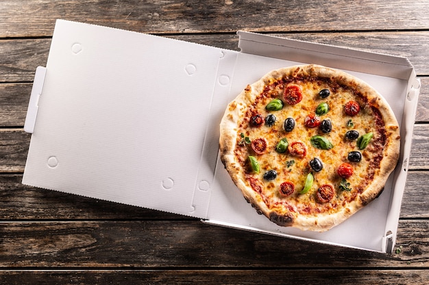 Pizza em uma caixa de papelão na mesa pronta para o cliente