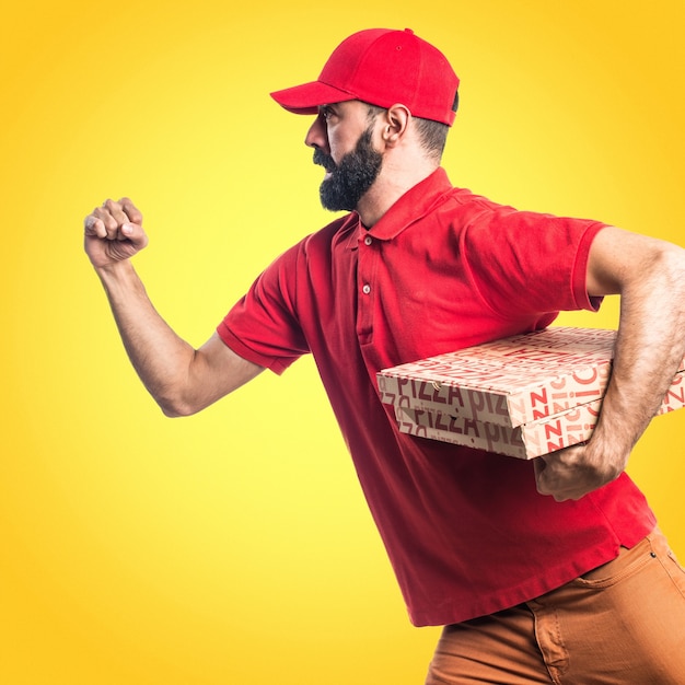 Pizza entrega hombre corriendo rápido sobre fondo de colores