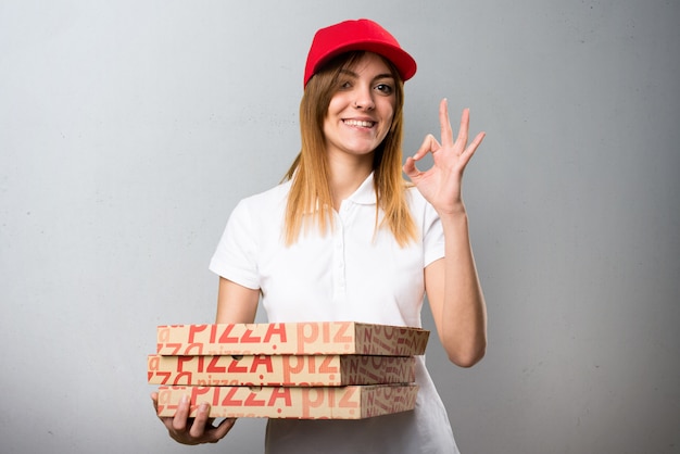 Pizza entrega mulher fazendo sinal de OK no plano de fundo texturizado