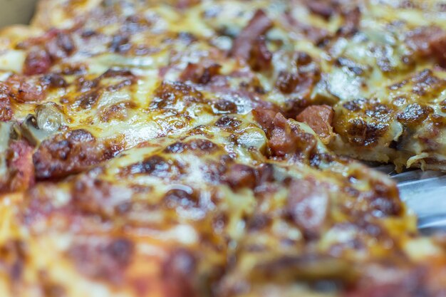 La pizza es una comida italiana que se sirve en una tabla de círculo de madera