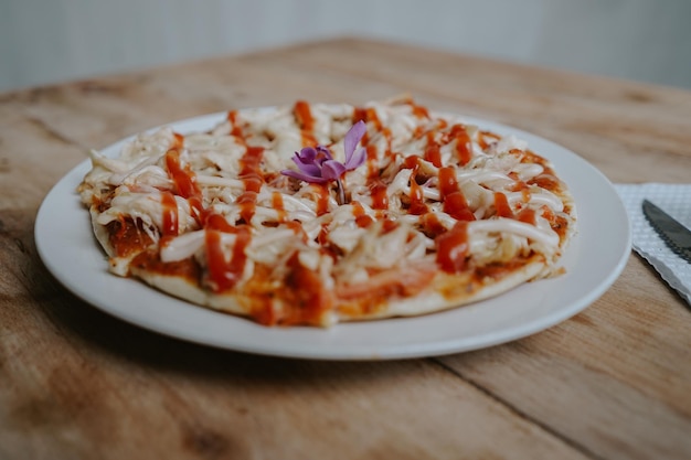 Una pizza con una flor morada