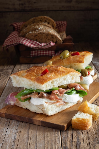 Foto pizza de focaccia con ensaladas de mozzarella de jamón y aceitunas