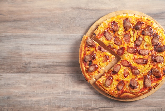 Pizza en el fondo de la mesa de madera.