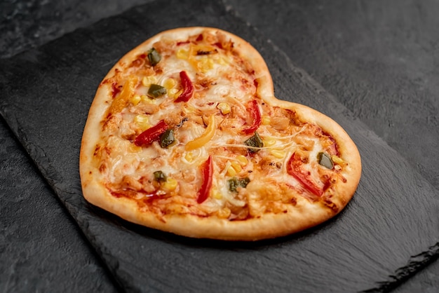 Pizza en forma de corazón para el día de San Valentín en pizarra