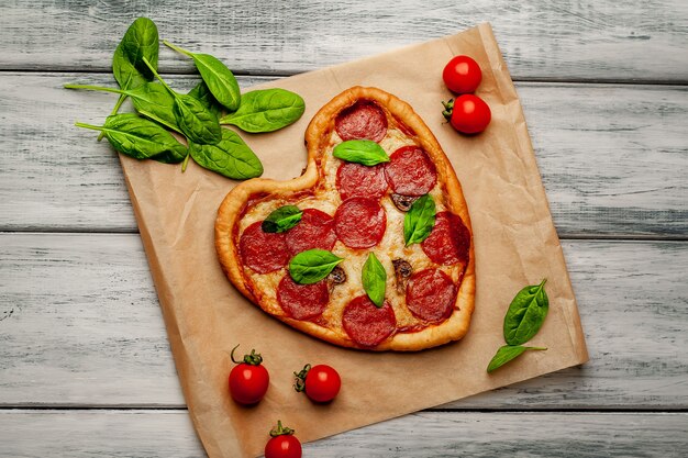 Pizza en forma de corazón sobre una mesa de madera