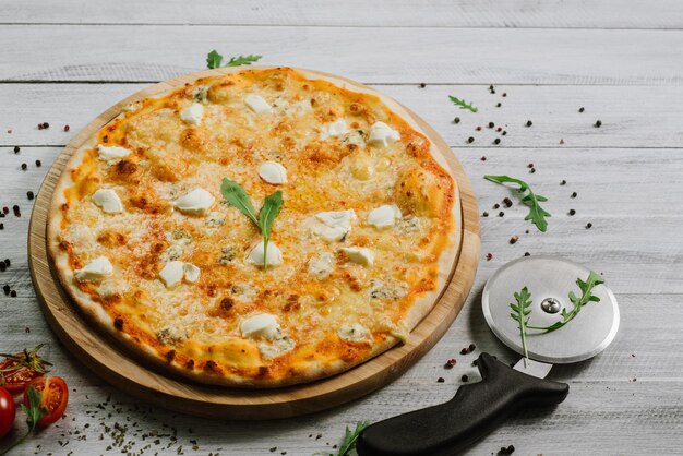 Pizza Formaggio com mussarela, queijo emental e queijo philadelphia em fundo de madeira