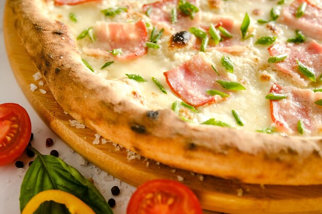 Pizza fresca y apetitosa está sobre la mesa. Comida de un restaurante italiano. Cocinar pizza. Ingredientes de pizza. Cena con amigos.