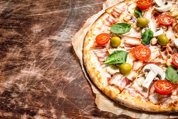 Pizza fresca con carne y tomates.