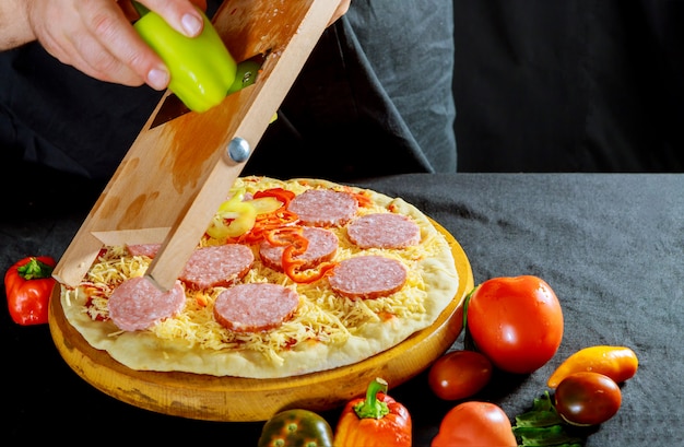 Pizza fresca con masa cruda para pizza con ingredientes y pimienta para pizza. Lo tradicional