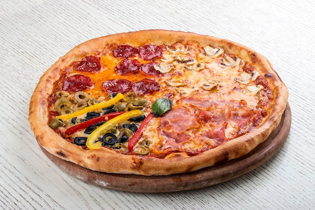 Pizza für Kinder mit Würstchen und Pommes Frites auf einem Holzbrett