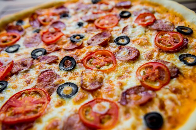 Pizza grande em uma mesa de madeira. Restaurante.