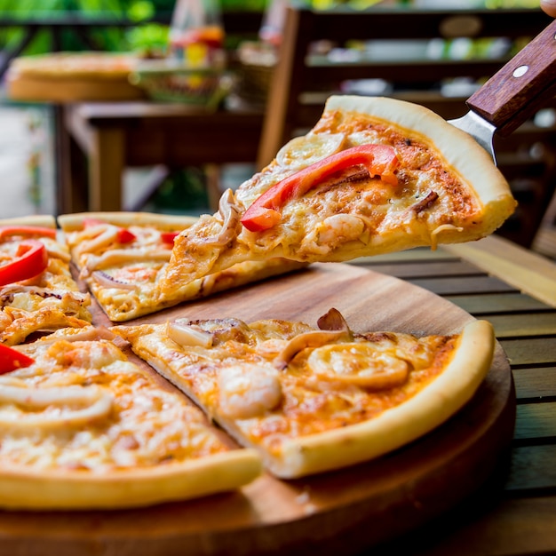 Pizza grande em uma mesa de madeira.