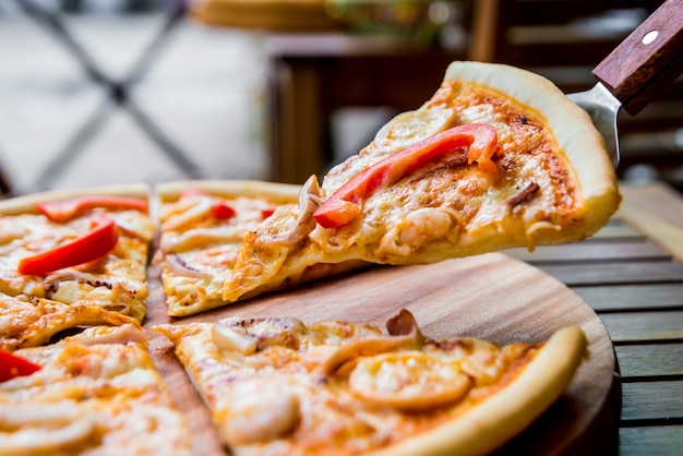 Pizza grande em uma mesa de madeira.