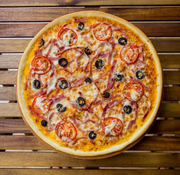 Pizza grande en una mesa de madera. Restaurante.