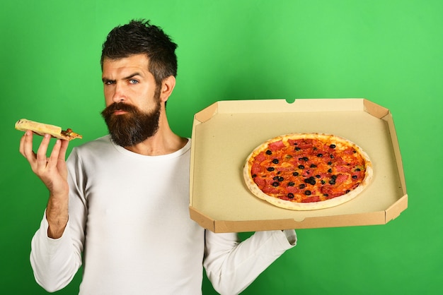 Pizza guapo sexy barbudo con cara seria comiendo pizza hombre comiendo pizza y tiene caja