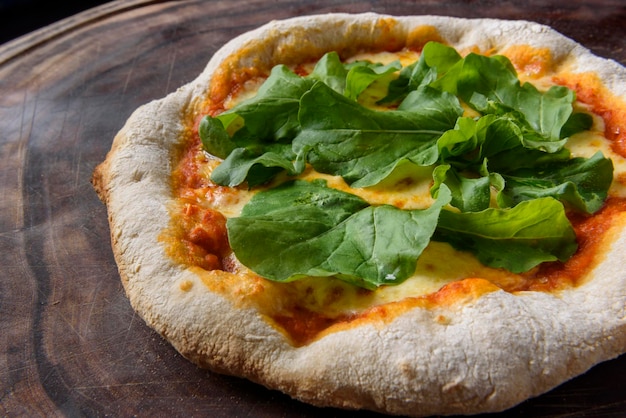 Pizza Hausgemachte Käsepizza mit Rucola über Holz