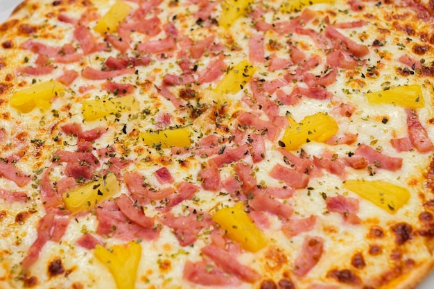 Pizza havaiana. Closeup de pizza coberta com queijo de presunto de abacaxi e orégano