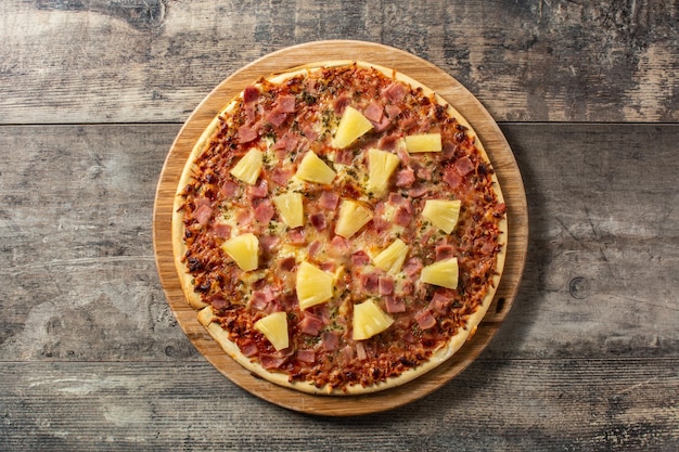 Pizza havaiana com abacaxi e queijo na mesa de madeira