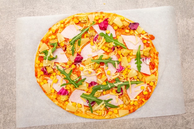 Pizza havaiana crua em pergaminho na superfície da pedra.