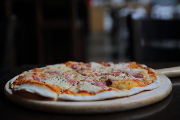 Pizza havaiana, pizza com abacaxi e presunto com molho de queijo e tomate no fundo de madeira, comida italiana